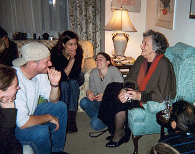 Elderly PK sitting in livingroom with young adult students